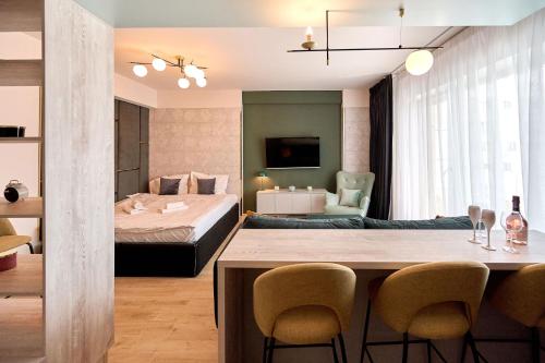 a room with a bed and a dining table and chairs at Vogue Sunrise View - Infinity Pool & Spa Resort in Mamaia Nord