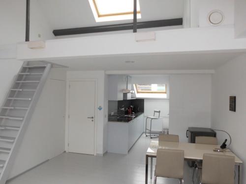 uma cozinha e sala de jantar com uma escada num loft em Aparthotel Midi Residence em Bruxelas