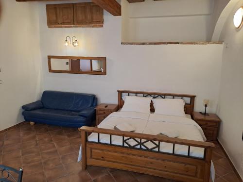 a bedroom with a bed and a blue chair at Řehořův dům in Jihlava