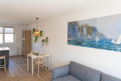 Una sala de estar con un sofá y un cuadro en la pared. en Appartement aan Zee, en Noordwijk aan Zee