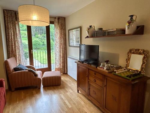 una sala de estar con TV en un tocador y un espejo en Sallent de Gállego - Formigal - Pirineos Sur, en Sallent de Gállego