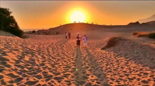 a group of people walking on a beach at sunset at Villa Ilda - Deluxe Holiday Villa - KALKAN-ANTALYA in Kalkan