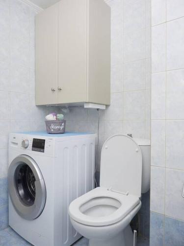 a bathroom with a toilet and a washing machine at Casa di Andreo in Faraí