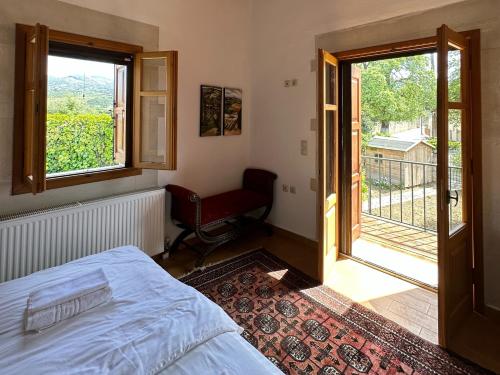 een slaapkamer met een bed, een raam en een stoel bij Ancient Eleftherna Villas in Elefterna