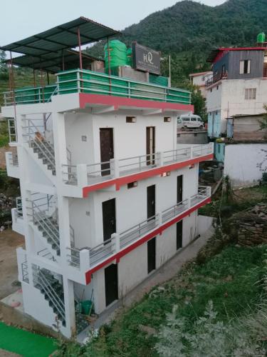 - un bâtiment blanc avec des balcons sur le côté dans l'établissement Hotel Arindam, à Phata