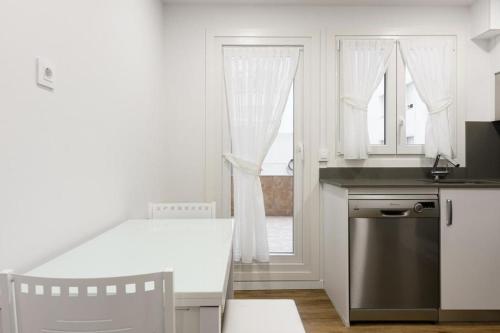 a kitchen with a table and a sink and a window at Vacacional in Laredo