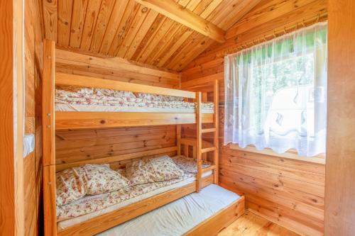 a bedroom with two bunk beds in a log cabin at KARMAZYNOWY RAJ in Dąbki
