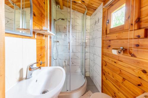 a bathroom with a sink and a toilet and a tub at KARMAZYNOWY RAJ in Dąbki