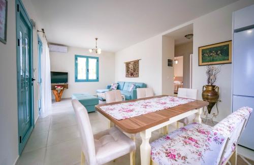 a dining room and living room with a table and chairs at Meliades villas in Apolpaina