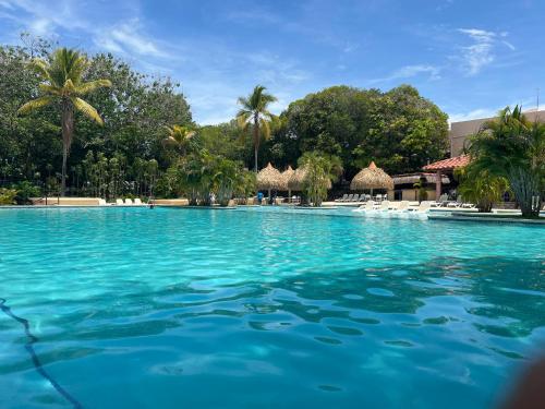 a large swimming pool with blue water and palm trees at Aurora Luxury Suite con acceso a la playa in Chame