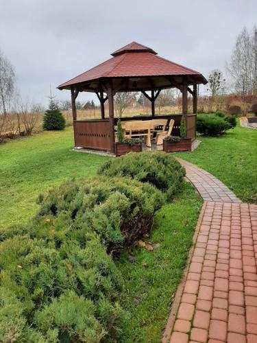 a gazebo with a picnic table in a park at Pod żurawiem Szwałk 1 in Szwalk