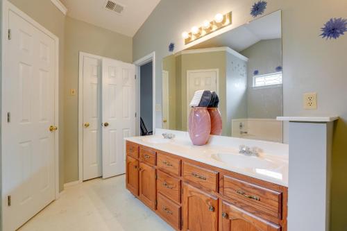 La salle de bains est pourvue d'un lavabo et d'un grand miroir. dans l'établissement Horn Lake Home with Yard - 8 Mi to Graceland!, à Horn Lake