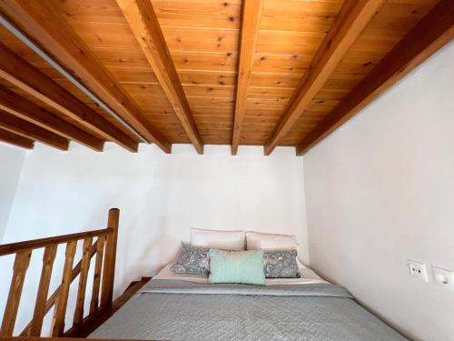een bed in een kamer met een houten plafond bij Ambela House Soroni in Soroni