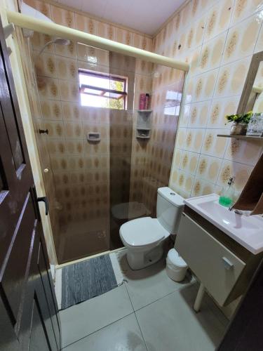 a bathroom with a shower and a toilet and a sink at Pousada Justi Oliveira in Louro Müller