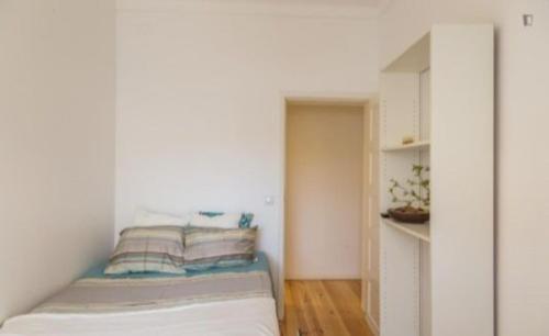 a small bedroom with a bed and a book shelf at Adelino apartamentos in Camarate