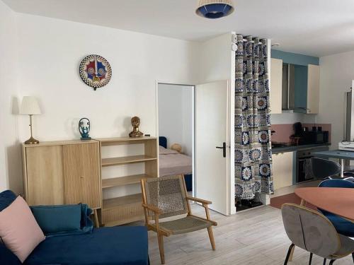 sala de estar con sofá azul y dormitorio en Appartement cosy à Bordeaux, en Burdeos