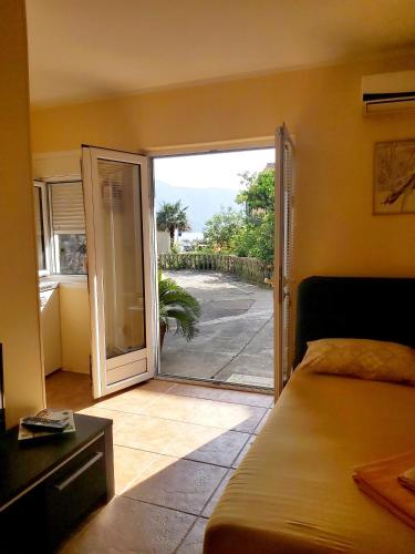 a bedroom with a door open to a patio at Risan center apartment in Risan