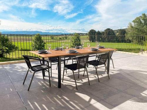 a wooden table and chairs on a patio at Appartement dans un Mas provençal in Allan