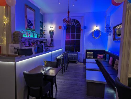 un bar con illuminazione blu in un ristorante di Acqua Beach Weymouth a Weymouth