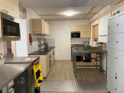 a large kitchen with wooden cabinets and a sink at Bohobos Hostel in Antibes