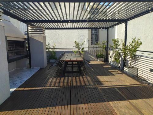a wooden deck with a picnic table on a building at Depto de lujo con pileta en San Telmo in Buenos Aires