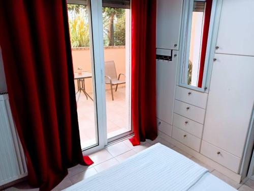 una camera da letto con tende rosse e vista su un patio di Bed and Garden a Kanoni