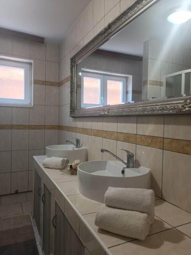 a bathroom with two sinks and a large mirror at Kuca za odmor Vugica in Polje