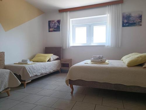 a bedroom with two beds and a window at Kuca za odmor Vugica in Polje