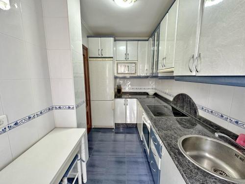 a small kitchen with white cabinets and a sink at Isla Mar - 5833 in Isla