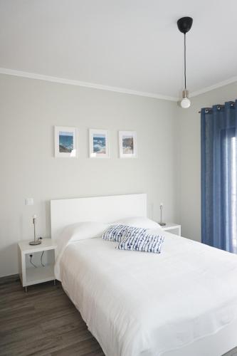 een witte slaapkamer met een groot wit bed bij Casa Gaio's in Parchal