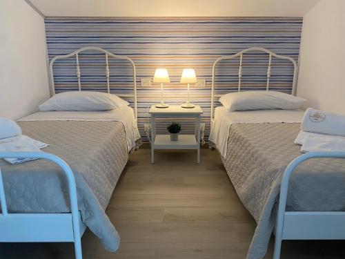 a bedroom with two beds and a night stand with two lamps at Borgo Incoronata B&B in Vasto