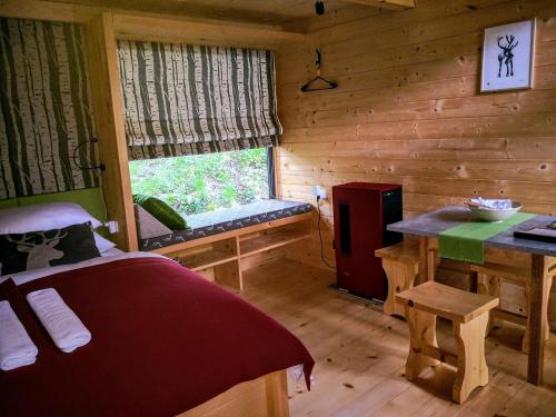 a bedroom of a log cabin with a bed and a window at Mountain lodge Forte Emilia in Kobarid