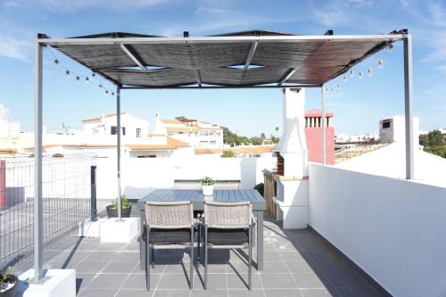 a patio with a pergola and chairs on a roof at Casa Gaio's in Parchal