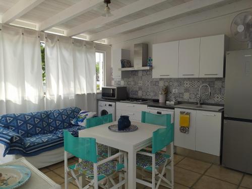 een keuken met een tafel en stoelen en een bank bij Casa blu in Conca Specchiulla