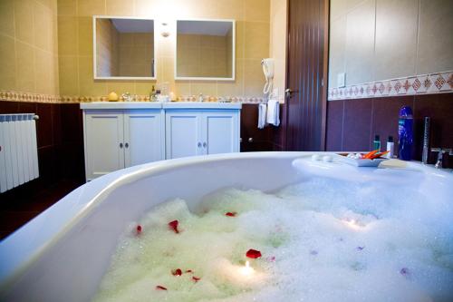 a bath tub filled with lots of bubbles at Casa A Canteira in Vimianzo