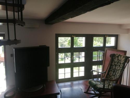 a living room with two windows and a flat screen tv at Monastero Maggiore 2 in Cividale del Friuli