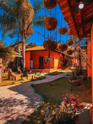 a house with a garden with flowers in front of it at Chalés Flor de Manacá in Alto Paraíso de Goiás