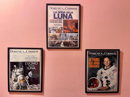 four movie posters hanging on a pink wall at Minardi Apartments in Vercelli