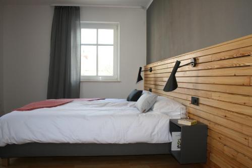 a bedroom with a large bed with a wooden headboard at FEWO am Markt in Neustadt in Sachsen