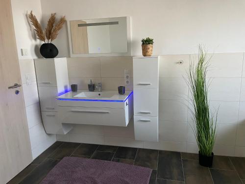 a white bathroom with a sink and a mirror at Wohnung 13 in Wildeshausen