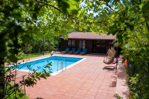 a swimming pool in a yard with a house at Quinta da Mal-disposta, cabin lodge Countryhouse in Resende