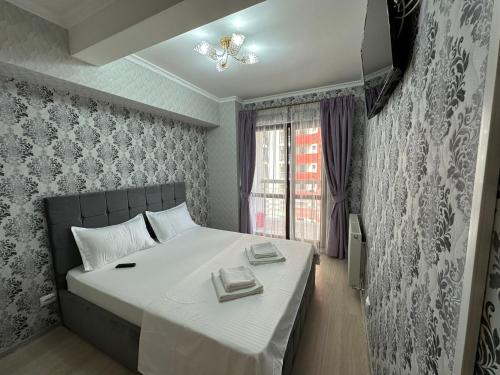 een slaapkamer met een bed met twee handdoeken erop bij Renting Solutions Luxury in Iaşi