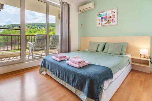ein Schlafzimmer mit einem Bett mit zwei rosa Handtüchern darauf in der Unterkunft Villa Poesia, Harmony Hills Residence in Rogachevo