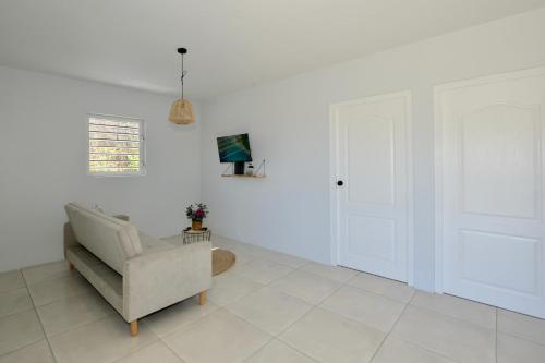 a white living room with a chair and a tv at Beach House,Villa Santirome/Free Wifi,Parking in Westpunt