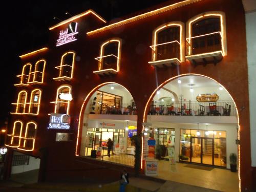a building with neon signs on the side of it at Hotel Plaza San Carlos in Xicotepec de Juárez