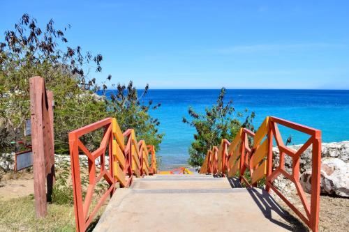 a wooden pathway to the beach with the ocean in the background at Beach House,Villa Santirome/Free Wifi,Parking in Westpunt