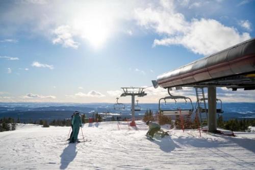 a person on skis in the snow next to a ski lift at Leilighet med panoramautsikt Sjusjøen Innendørs parkering in Sjusjøen