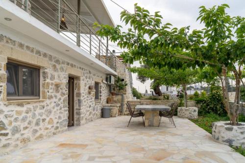 a patio with a table and chairs next to a building at Rafaela holiday home in Pitsidia