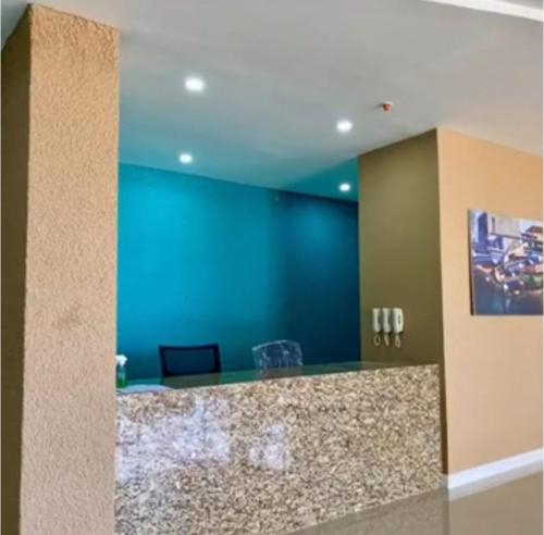 een lobby met een balie en een blauwe muur bij Impeccable 2-BR Apartment-Ornella Villa at Bayfront Villa in Portmore