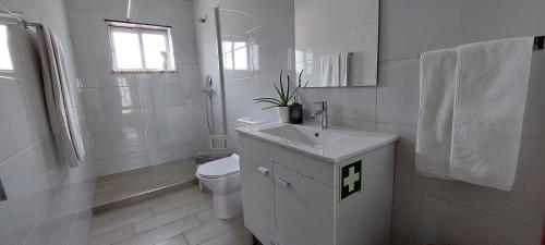a white bathroom with a sink and a toilet at Lideal in Coimbra